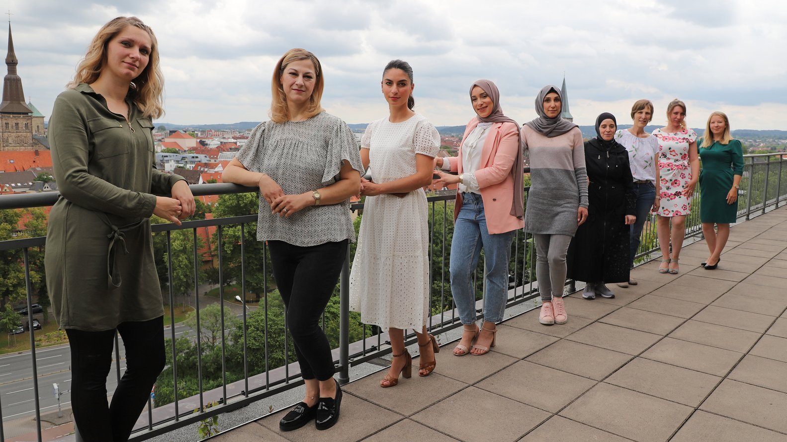 Familienbegleiterinnen der Stadt Osnabrück stehen auf einer Terrasse mit Blick über die Stadt