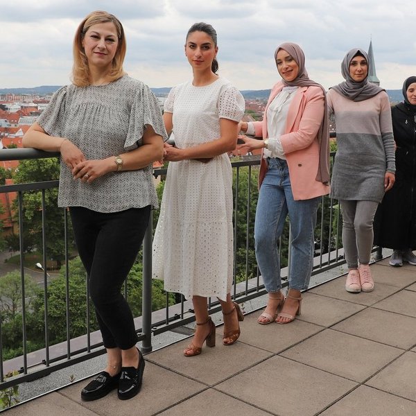 Familienbegleiterinnen der Stadt Osnabrück stehen auf einer Terrasse mit Blick über die Stadt
