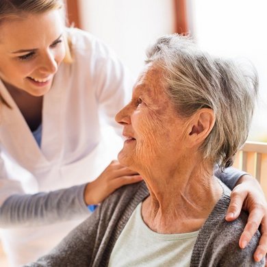 Pflegekraft betreut eine Seniorin