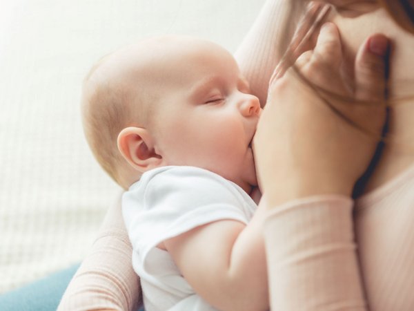 Frau stillt ihr Baby an der Brust