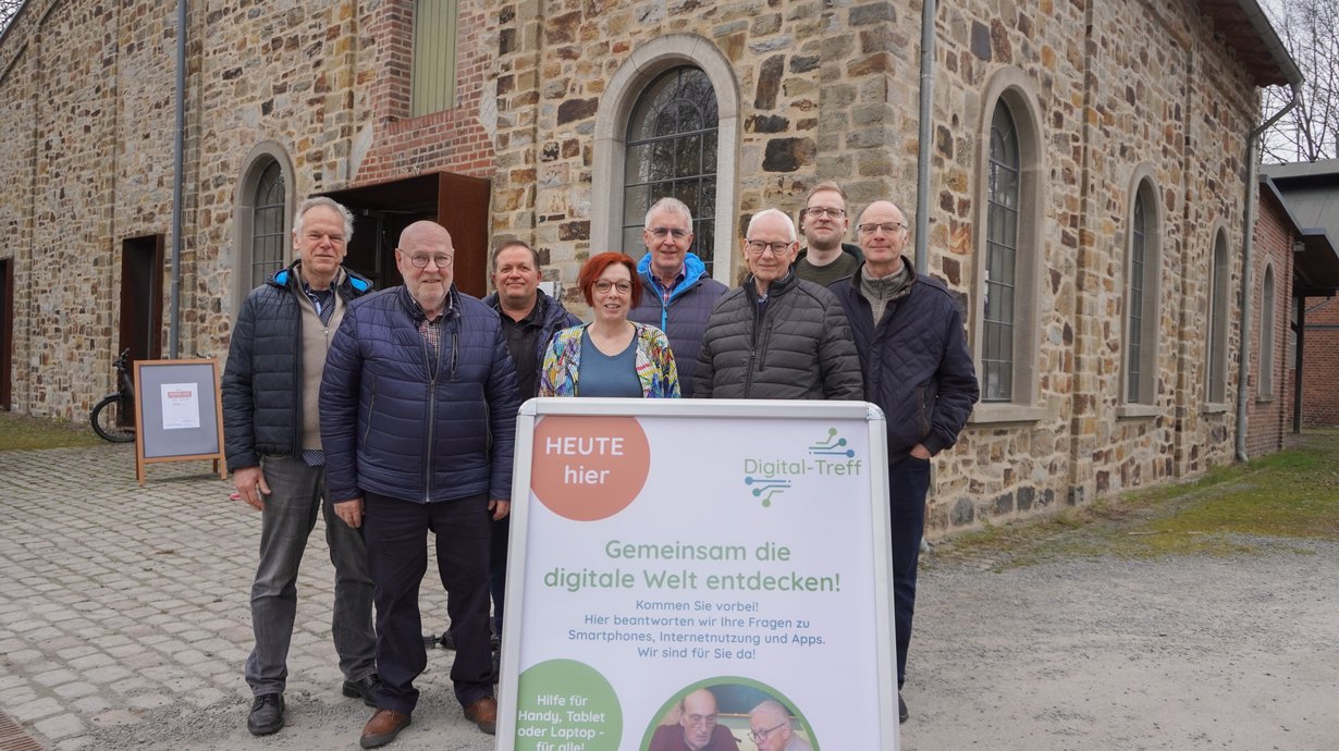 Eine Gruppe Menschen steht vor einem alten Gebäude